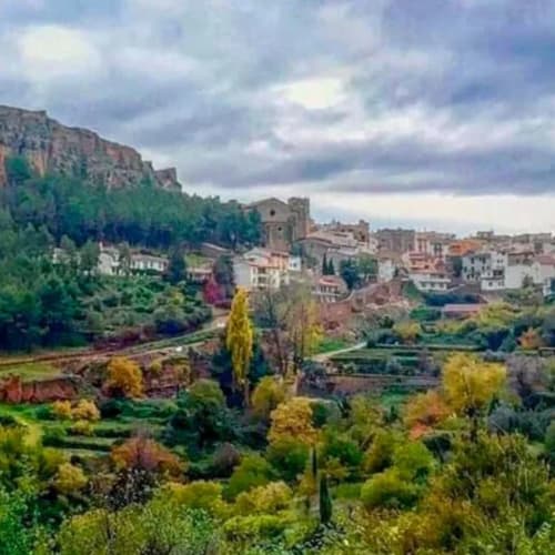 El hotel Rustikalpuente domina un pintoresco pueblo español con edificios coloridos rodeados de exuberante campiña verde