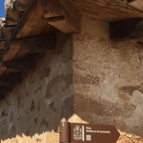Muros de piedra históricos y vigas de madera en Rustikalpuente, sitio patrimonial Muralla de Alpuente en España