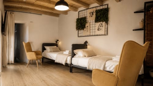 Modernes Schlafzimmer in Bergamo mit zwei Betten, Holzbalken, Senfsesseln und zeitgenössischer Einrichtung