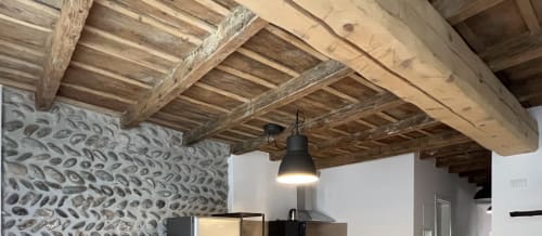 Freiliegende Holzbalken und gemusterter Steinmauern in modernem Apartment im Zentrum von Bergamo