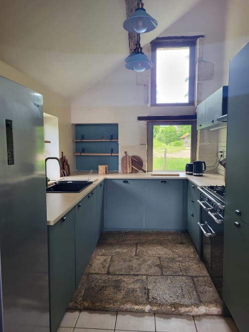 Modern kitchen in Maison de la Lune cottage at Domaine Des Forges De La Vache, Raveau with blue cabinetry and countryside