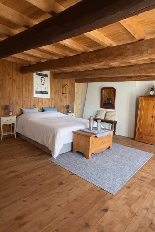 Chambre spacieuse aux poutres apparentes de la villa Le 1830 à Églisolles, avec lit queen-size, décor rustique