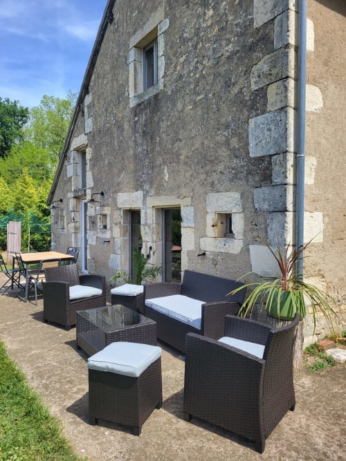 Outdoor patio with black wicker furniture at Domaine Des Forges De La Vache cottage in Raveau, France