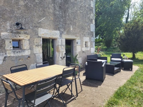 Outdoor patio with dining table and lounge seating at Domaine Des Forges De La Vache cottage in Raveau, France