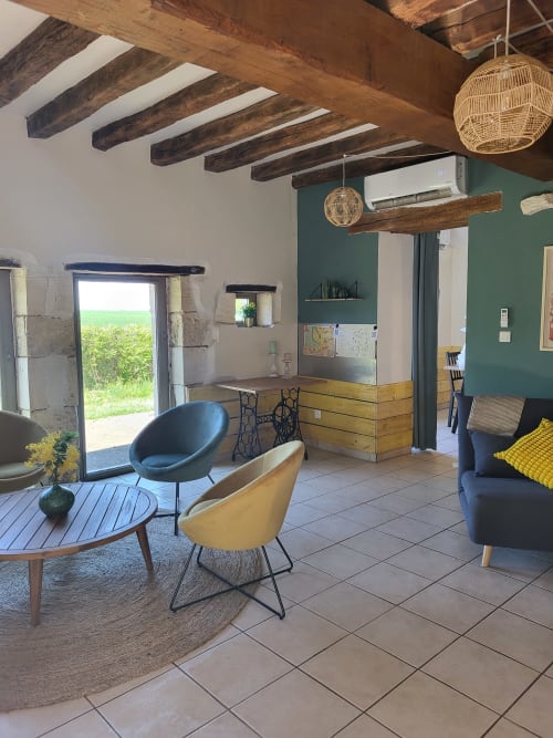 Modern rustic cottage living room at Domaine Des Forges De La Vache with exposed wooden beams, green accent wall, and