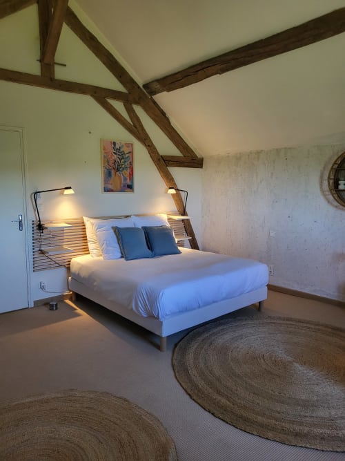 Modern bedroom in Maison de la Lune cottage at Domaine Des Forges De La Vache, Raveau with exposed beams and rustic circular