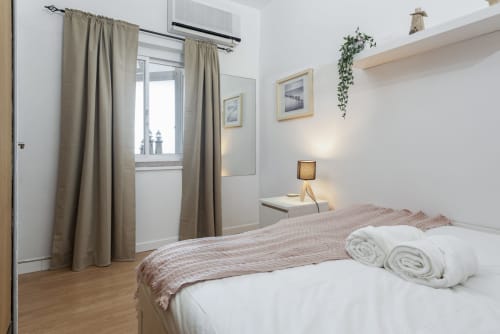 Quarto luminoso do hotel RB Algarve em Vilamoura com cama de casal, roupa branca, cortinas bege e vista para o jardim