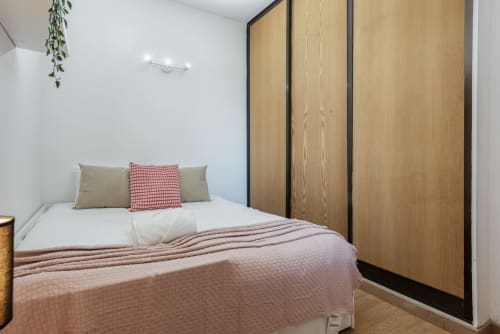 Quarto luminoso do hotel RB Algarve com cama de casal, roupa de cama rosa, guarda-roupa em madeira e vista para o jardim em Vilamoura