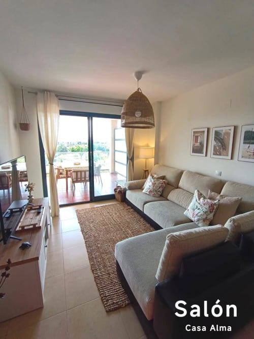 Séjour contemporain de l'appartement Casa Alma à Sant Jordi avec canapé beige, lampe suspendue tissée et vue sur la terrasse