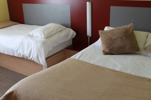 Lits jumeaux aux draps blancs et oreillers marron à l'Hôtel Libre de La Vespière, France