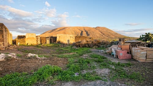 Edificios rurales y montaña volcánica dorada en Hotel Rural El Cabo de Villaverde, España