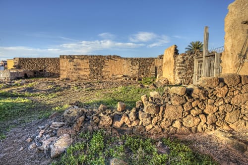 Ruinas de piedra rústica con muros desgastados en Hotel Rural El Cabo de Villaverde, España, bajo un cielo azul despejado