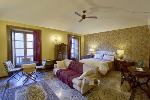 Suite spaziosa presso l'A Casa Armenia B&B a Torino con pareti gialle, carta da parati floreale, letto queen, zona living e vista sulla città