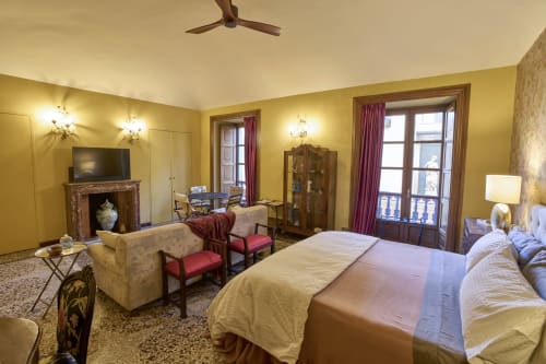 Camera di lusso presso A Casa Armenia B&B, Torino, con pareti gialle, camino, vista sulla città e arredi d'epoca
