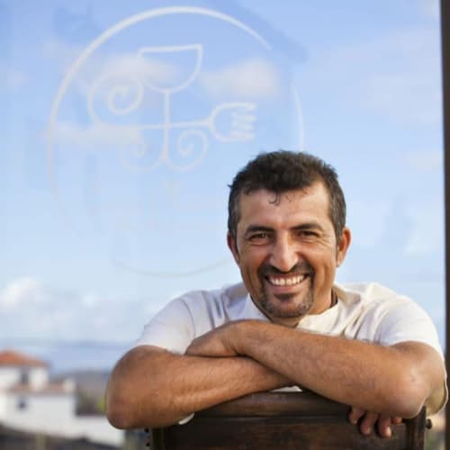 Hombre sonriente con brazos cruzados en Hotel Rural El Cabo, Villaverde, España, con vistas al océano