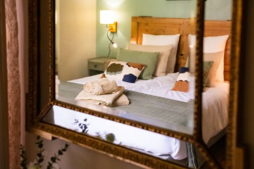 Cozy bedroom at Le Jardin Secret cottage in Grignan with wooden beds, green accents, and garden view