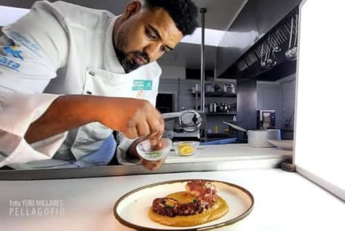Chef del Hotel Rural El Cabo emplata un plato gourmet con precisión en una cocina moderna, Villaverde