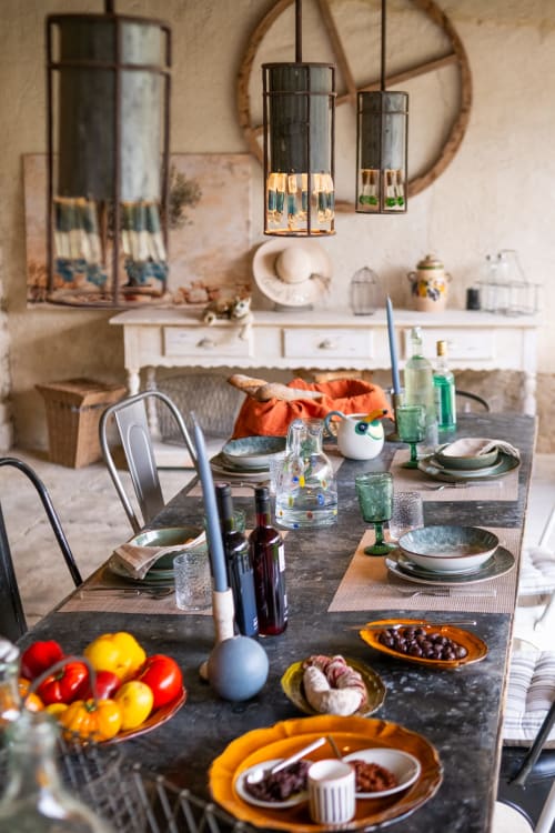 Elegant dining room at Le Jardin Secret cottage in Grignan with set table, fresh produce, and modern pendant lighting