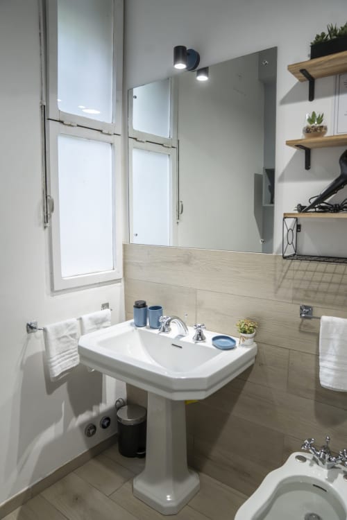 Modern bathroom in LikeHome Mentessi apartment, Ferrara with pedestal sink, mirror, shelving, and accessible design
