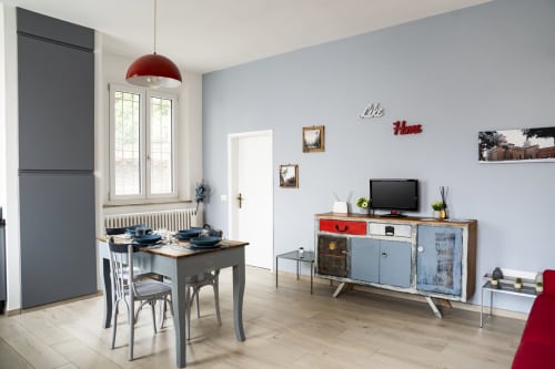 LikeHome Mentessi apartment in Ferrara with dining table, TV unit, red pendant light, and modern furnishings