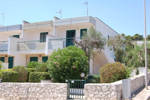 Villa mediterranea bianca con vista mare a Santa Cesarea Terme, giardino terrazzato, ulivi e persiane verdi