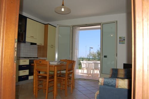 Cucina e zona pranzo dell'appartamento La Terrazza degli Ulivi a Santa Cesarea Terme con accesso a terrazza con vista mare