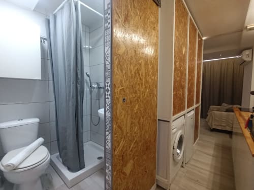 Baño moderno con ducha e inodoro junto a área de lavandería en el apartamento El Rincón de Sevilla, Sevilla