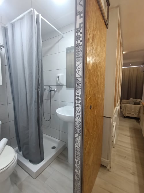 Baño moderno con ducha, inodoro y lavabo en el apartamento El Rincón de Sevilla, Sevilla España