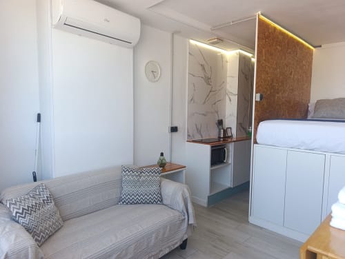 Estudio moderno en El Rincón de Sevilla con sofá, cama, cocina americana y aire acondicionado