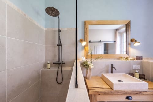 Modern bathroom at Le Jardin Secret cottage in Grignan with rainfall shower, wooden vanity, and mirror lighting