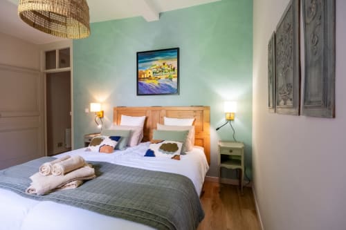 Bright bedroom at Le Jardin Secret BnB in Grignan with mint walls, wooden beds, and modern amenities