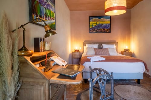 Cozy cottage bedroom at Le Jardin Secret in Grignan with desk, comfortable bed, ambient lighting, and rustic décor