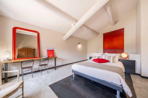 Modern bedroom at Le Jardin Secret cottage in Grignan with red accents, pool view, and contemporary furnishings