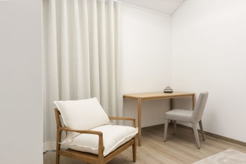 Espaço de trabalho moderno no RB Algarve Vilamoura com secretária de madeira, cadeira confortável e zona de estar próxima