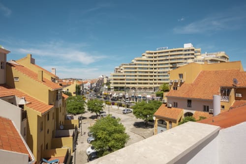 Edifícios coloridos e resort à beira de uma praça central em Vilamoura, Portugal, com arquitetura mediterrânea