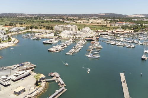 Marina do RB Algarve Vilamoura com barcos ancorados, apartamentos à beira-mar e colinas ao fundo