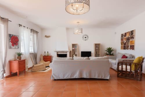 Sala de estar espaçosa na villa JUDY em RB Algarve, Albufeira, com pisos em terracota, sofá bege, lareira e design moderno
