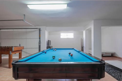 Sala de recreação iluminada com mesa de bilhar azul e bolas de sinuca na villa RB Algarve em Albufeira, Portugal