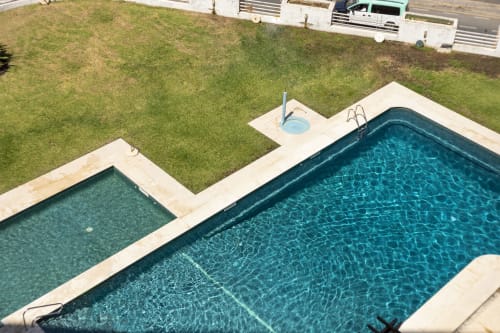 Vista aérea de duas piscinas do apartamento RB Algarve Vilamoura com jardim e estacionamento em Portugal