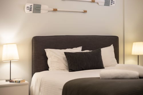 Cama estofada cinza-escuro com almofadas brancas no quarto MILA Vilamoura do hotel RB Algarve