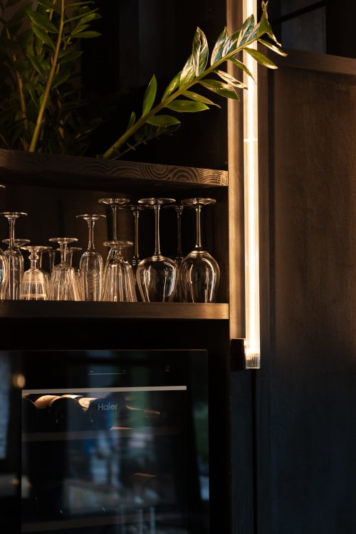 Elegant black shelving with wine glasses and potted plant at Moulin Moulin, Dannes