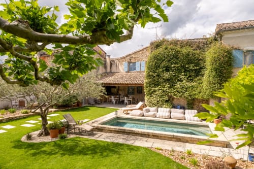 Tranquil courtyard at Le Jardin Secret in Grignan with pool, loungers, ivy-covered walls