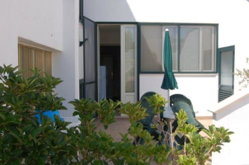 Vista giardino dell'appartamento La Casetta a Santa Cesarea Vacanze con patio, piante verdi e ombrellone turchese