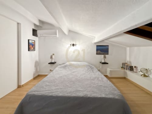 Chambre duplex moderne à L'Île-Rousse avec lit queen-size, murs blancs, parquet, climatisation et vue sur la ville