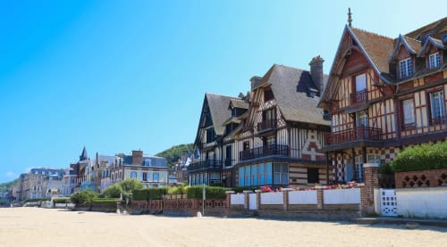 Libre Hôtel beachfront facade in La Vespière with half-timbered Norman architecture and sandy beach