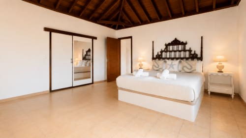Chambre spacieuse à l'appartement Casa Miranda de Sara & Gino Fuerteventura, Corralejo avec tête de lit ornementale et mobilier crème