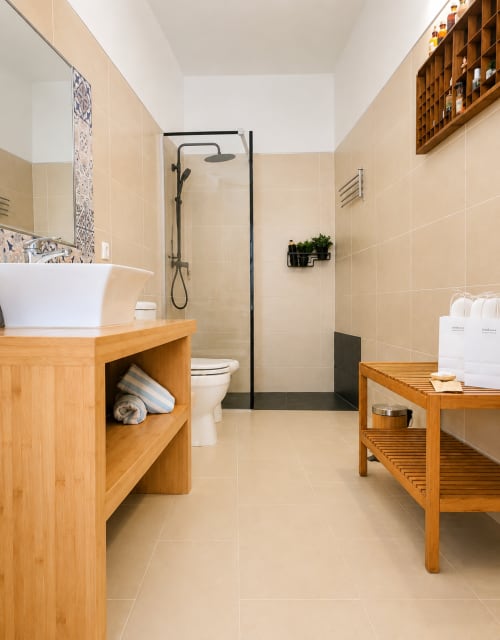 Salle de bain moderne aux carrelages beige, meuble vasque en bois, douche à l'italienne et touches décoratives chez Sara & Gino Fuerteventura