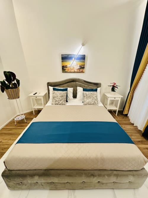 Camera Deluxe Matrimoniale a St Mary Major Loft Roma con vista sulla città, letto rivestito in tonalità talpa, comodini bianchi e biancheria color crema