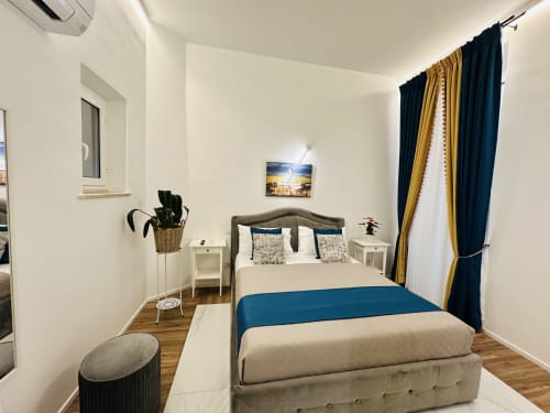 Camera matrimoniale deluxe St Mary Major Loft a Roma con vista sulla città, arredi eleganti e tende blu