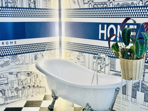 Lussuoso bagno nella St Mary Major Loft di Roma con vasca freestanding, piastrelle blu e bianche raffiguranti l'architettura romana